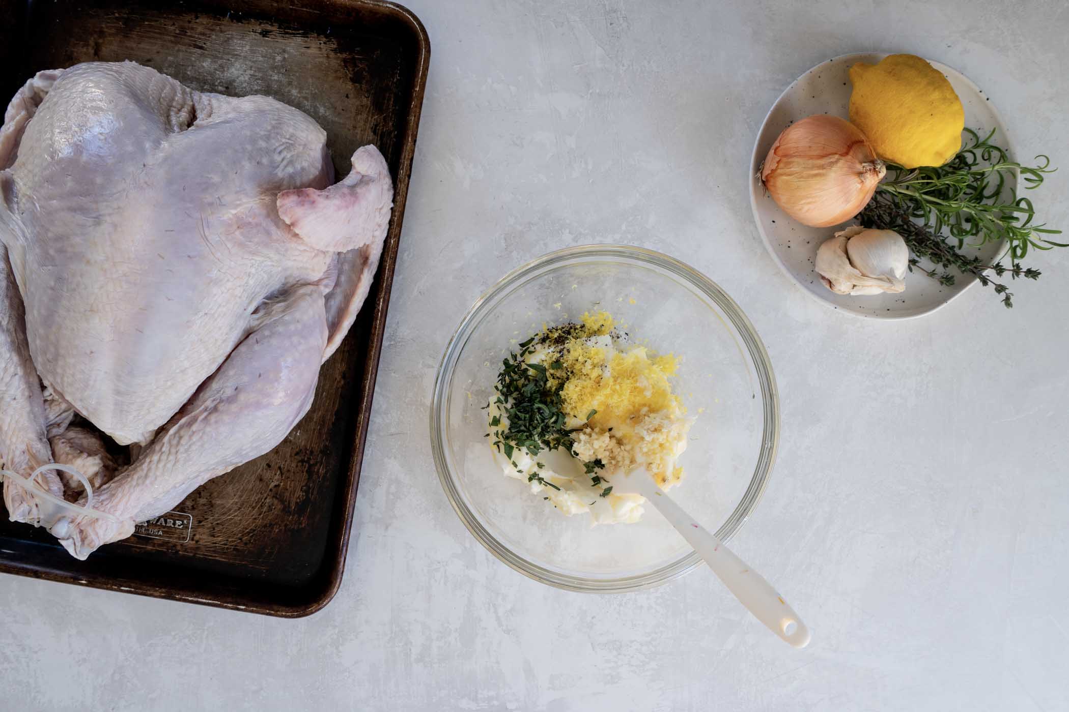 This easy Thanksgiving turkey recipe is the best turkey I've ever made! Rubbing the turkey with garlic herb butter before baking keeps it moist and gives it the most incredible flavor. This post has everything you need to know to make the most perfect, juicy, flavorful oven roasted turkey! Herb butter ingredients combined in a small bowl.